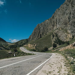 Road by mountains against clear sky