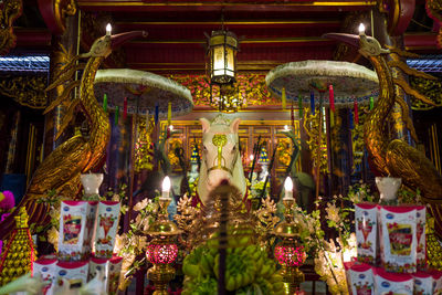 Statues in illuminated temple outside building