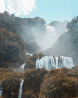 Scenic view of waterfall against sky