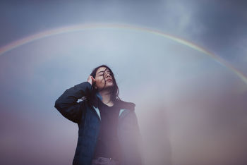FULL LENGTH OF WOMAN STANDING AGAINST RAINBOW