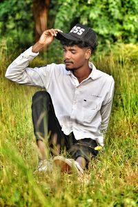 Young man using mobile phone while sitting on field