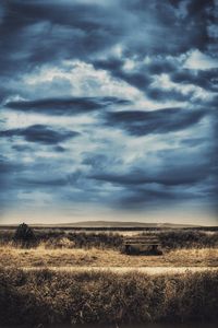 Scenic view of field against cloudy sky