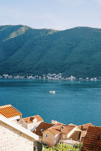 High angle view of townscape by sea against mountain