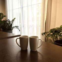 Coffee cup on table against window at home