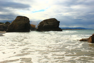 Rocks on beach against sky