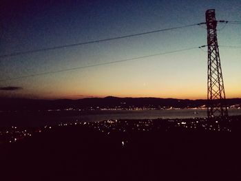 Silhouette electricity pylon against sky during sunset