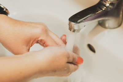 A woman washing her hands in the bathroom at home