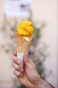 Cropped image of hand holding ice cream in a cone