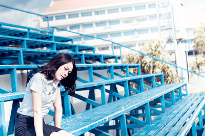 Woman sitting on bleacher