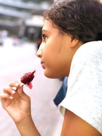Close-up side view of girl eating flavored ice