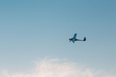Low angle view of airplane against sky during sunset