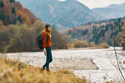 Full length of young woman standing on mountain
