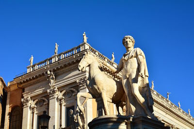 Low angle view of statue against blue sky