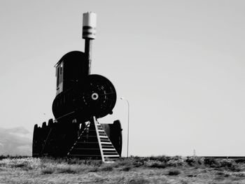 Low angle view of built structure on field against clear sky