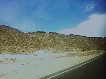 Scenic view of mountains against blue sky