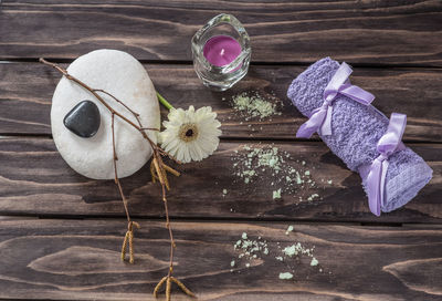 Close-up of pebbles with tea light candle and towel on table