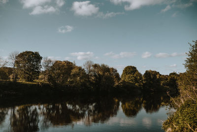 Reflection of trees in lake against sky