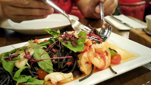 Close-up of man preparing food in plate