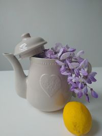 Close-up of purple roses on white table