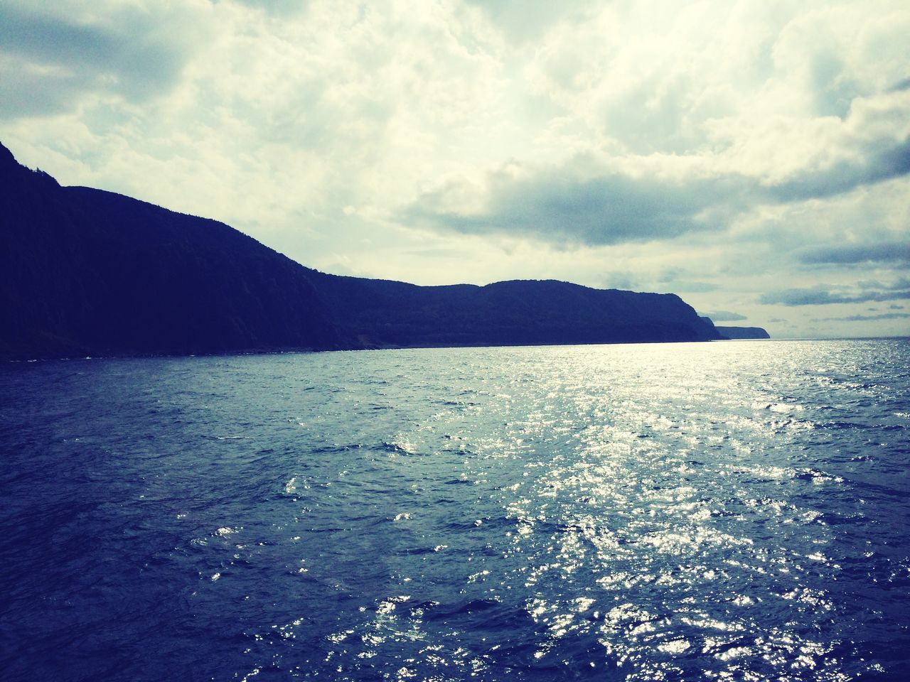 water, sea, sky, tranquil scene, scenics, tranquility, beauty in nature, mountain, waterfront, cloud - sky, nature, idyllic, cloudy, rippled, cloud, mountain range, beach, outdoors, dusk, calm