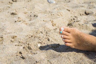 Midsection of woman on sand at beach
