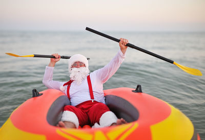 Rear view of man kayaking in sea