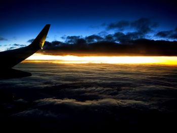 Airplane flying over cloudscape during sunset