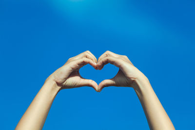 Cropped image of woman gesturing against sky