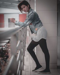 Portrait of woman standing against wall