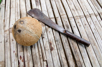 High angle view of coconut by knife on wooden table