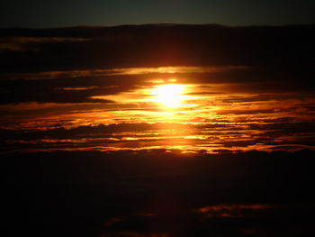 Sun shining through clouds at sunset