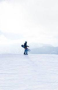 Rear view of man skiing on sea against sky