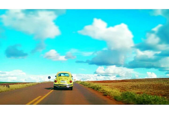 transportation, land vehicle, mode of transport, car, road, transfer print, sky, on the move, auto post production filter, travel, the way forward, road marking, cloud - sky, landscape, cloud, country road, diminishing perspective, street, field, vanishing point