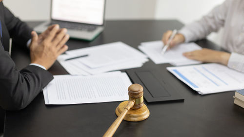 Midsection of business colleagues working on table