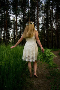 Rear view of woman standing in forest