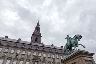 Low angle view of statue of building against cloudy sky