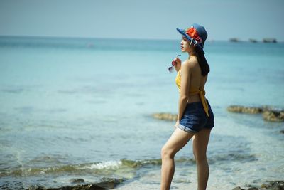 Full length of young woman standing on beach