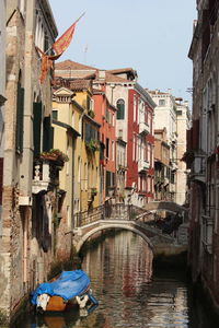 Bridge over canal amidst buildings in city