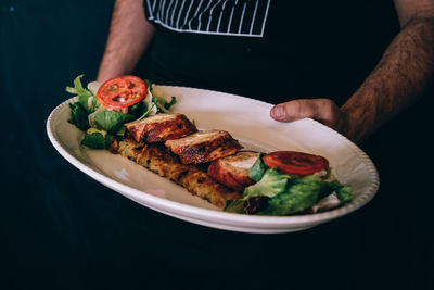 Close-up of person preparing food in plate