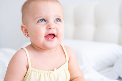 Portrait of cute baby boy lying on bed at home