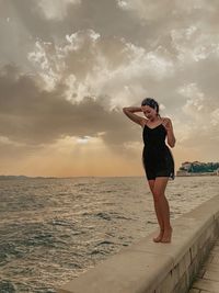 Full length of young woman standing on beach