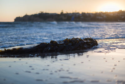 Close-up of sea against sky during sunset