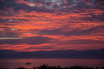 Scenic view of sea against dramatic sky during sunset