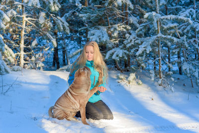 Woman playing with dog during winter