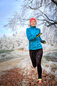 Full length of woman jogging on field during winter
