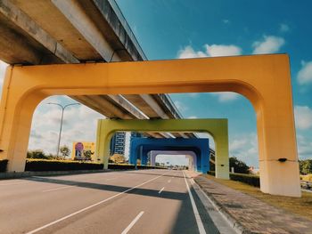 Road by bridge against sky in city