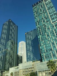 Low angle view of modern buildings against clear blue sky