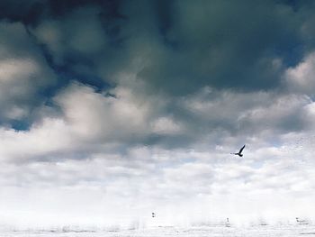 Low angle view of airplane flying against cloudy sky