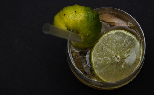 High angle view of lemon in glass over black background