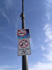 Low angle view of road sign against sky